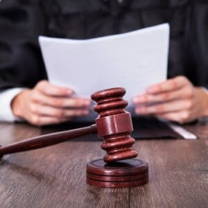 Wooden gavel with judge reading papers
